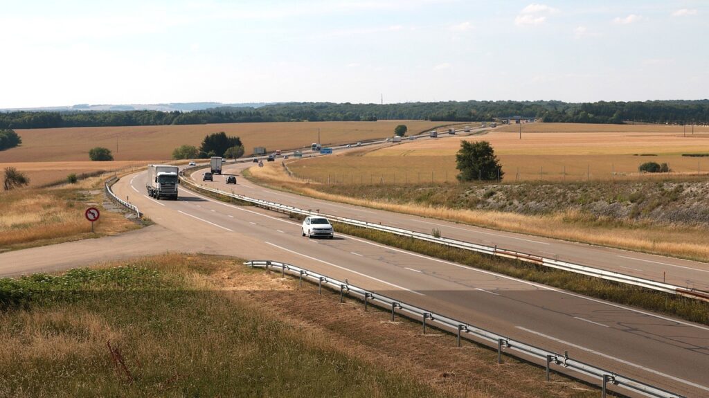Cars and trucks traveling on a divided highway through the countryside